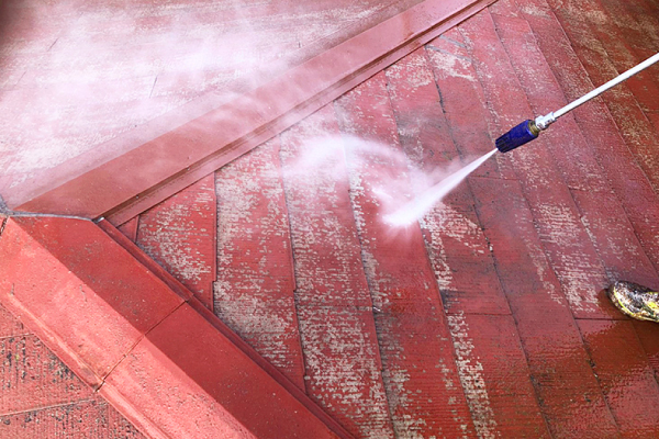 赤い化粧スレート屋根に付着した汚れを高圧洗浄で流します